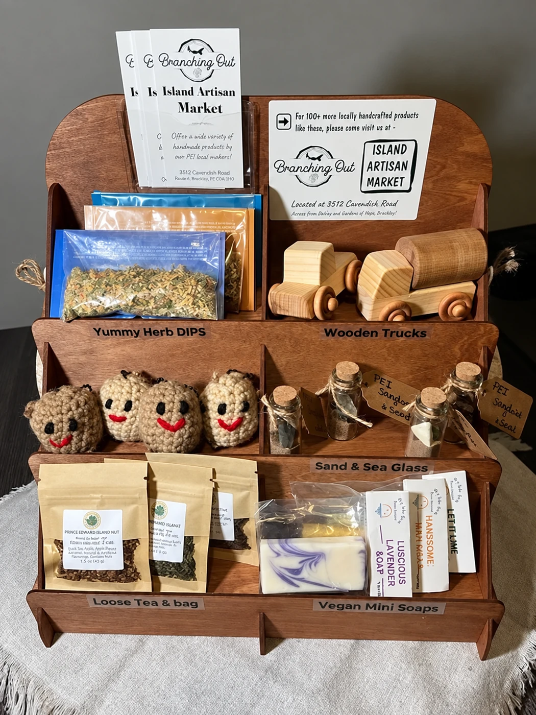A wooden shelf display of makers’ goods with Branching Out cards: wooden toy cars, sachets and soaps